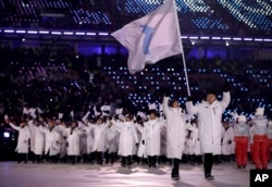 North Korea's Hwang Chung Gum and South Korea's Won Yun-jong carries the flag during the opening ceremony of the 2018 Winter Olympics in Pyeongchang, South Korea, Friday, Feb. 9, 2018. (AP Photo/Vadim Ghirda)