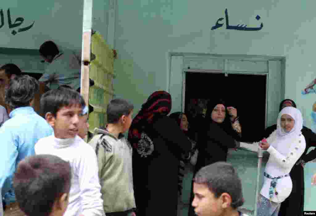 Residents gather outside a bakery to buy bread in al-Harak city, Deraa, Syria, March 27, 2013. 