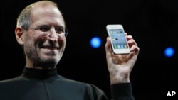 FILE - Apple CEO Steve Jobs smiles with a new iPhone at the Apple Worldwide Developers Conference in San Francisco. In the white-hot competition for tech talent, some workers are alleging Silicon Valley's top companies conspired to keep employees from switching teams, June 7, 2010.