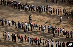 FILE - Kenyans queue to cast their votes at dusk at a polling station in downtown Nairobi, Aug. 8, 2017.