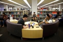 Students Sean Aitchison, left, and Alex Aguilar study in a library at Cal State Northridge campus in Los Angeles, 2016.