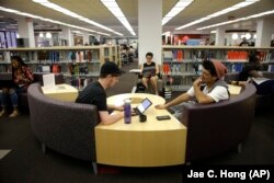 Students Sean Aitchison, left, and Alex Aguilar study in a library at Cal State Northridge campus in Los Angeles, 2016.