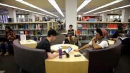 Students Sean Aitchison, left, and Alex Aguilar study in a library at Cal State Northridge campus in Los Angeles, 2016.