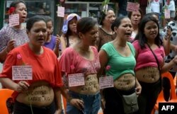 Mothers bare their bellies with messages protesting a ban on childbirth at home in the Manila suburb of Quezon City, May 2015. (AFP PHOTO)