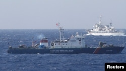 A ship (top) of the Chinese Coast Guard is seen near a ship of Vietnam Marine Guard in the South China Sea, about 210km offshore of Vietnam May 14, 2014. (Reuters)