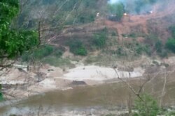 This handout from Kawthoolei Today taken and released on April 27, 2021 shows smoke rising from fires at a Myanmar military base along the bank of the Salween river, as seen from Mae Sam Laep town in Thailand's Mae Hong Son province, after the base was at