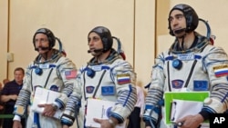 Russian cosmonauts Anton Shkaplerov (C) and Anatoly Ivanishin (R), and U.S. astronaut Daniel Burbank walk together after completing exams at the Star City space center outside Moscow, September 2, 2011