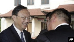 Chinese State Councilor Yang Jiechi, left, is greeted by a hotel executive as he arrives in Hanoi, Vietnam, June 17, 2014. 