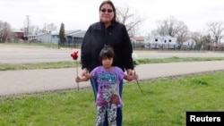 Delberta Seminole Eagleman stands with grandchild, 4-year-old Shawnee, whom she raises along with 5 others on the Fort Peck Indian Reservation, in Wolf Point, Montana, April 28, 2016. 