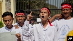 Min Min, second right, rights activist and political prisoner who was released from Insein Prison, shouts slogans demanding the release of all remaining political prisoners outside the prison in Yangon, Myanmar, Jan. 22, 2016. 