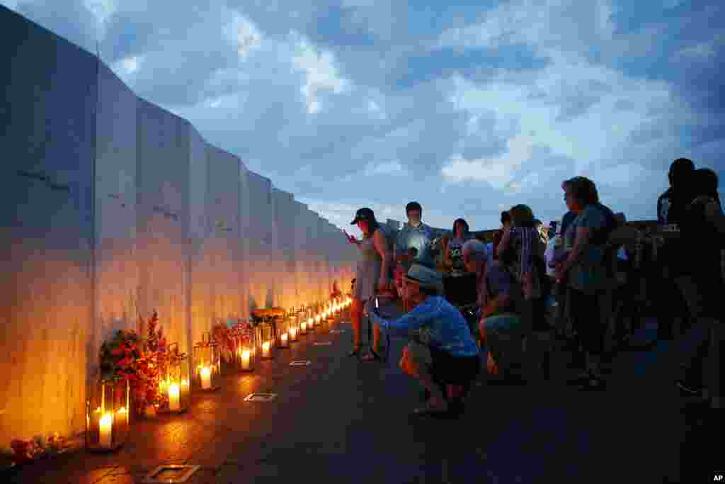 Candles in memory of the passengers and crew of Flight 93, are lit along the Wall of Names at the Flight 93 National Memorial in Shanksville, Pa., Sept. 10, 2016, as the nation marks the 15th anniversary of the Sept. 11 attacks.