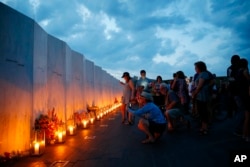 Candles in memory of the passengers and crew of Flight 93, are lit along the Wall of Names at the Flight 93 National Memorial in Shanksville, Pa., Sept. 10, 2016, as the nation marks the 15th anniversary of the Sept. 11 attacks.