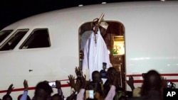 L’ex-président gambien Yahya Jammeh salue ses partisans avant d’entrer à bord de l’avion en destination de la Guinée équatoriale, à l’aéroport de Banjul, Gambie, 21 janvier. 