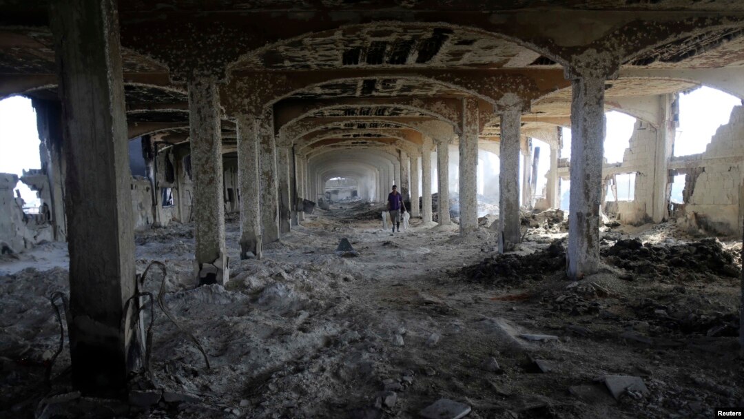 A Palestinian worker walks inside al-Awdah food factory, which witnesses said was shelled and torched by the Israeli army during the offensive, in Deirl al-Balah, central Gaza Strip, Aug. 14, 2014. 
