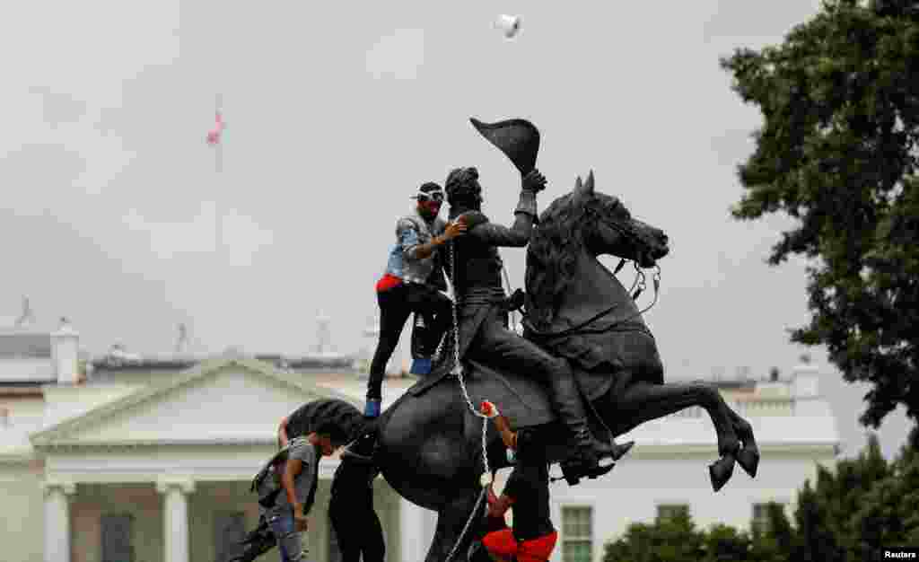 Protesters attach a chain to the statue of President Andrew Jackson to pull down in the middle of Lafayette Park outside the White House as someone throws a roll of toilet paper during racial inequality protests in Washington, D.C., June 22, 2020.