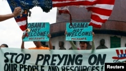 Aktivis dari kelompok Sanlakas meneriakkan slogan anti-pemerintah AS dan membakar bendera Amerika tiruan dalam pawai di wilayah Quezon, Manila (27/4), saat Presiden Obama berkunjung ke negara itu.