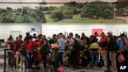 Migrantes cubanos hacen sus trámites de salida en el aeropuerto Daniel Odúber de Liberia, Costa Rica. Un segundo grupo de migrantes salió el jueves por la noche hacia El Salvador.