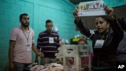 FILE - An electoral worker shows a ballot marked to Opposition Alliance presidential candidate Salvador Nasralla during the vote count in the general elections in Tegucigalpa, Honduras, Nov. 26, 2017.