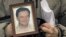 A November 2009 photo shows a portrait of lawyer Sergei Magnitsky who died in jail, held by his mother Nataliya Magnitskaya in Moscow. 