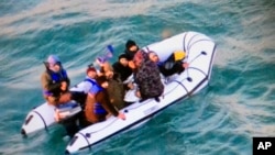 FILE: This image provided by the Marine Nationale (French Navy) shows migrants aboard a rubber boat after being intercepted by French authorities, off the port of Calais, northern France, Tuesday, 12.25.2018