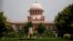 FILE - A gardener works on the lawns of the Supreme Court in New Delhi, India, Aug. 22, 2017.