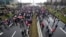 Protesters stand on the highway during a protest in Belgrade, Serbia, Dec. 11, 2021.