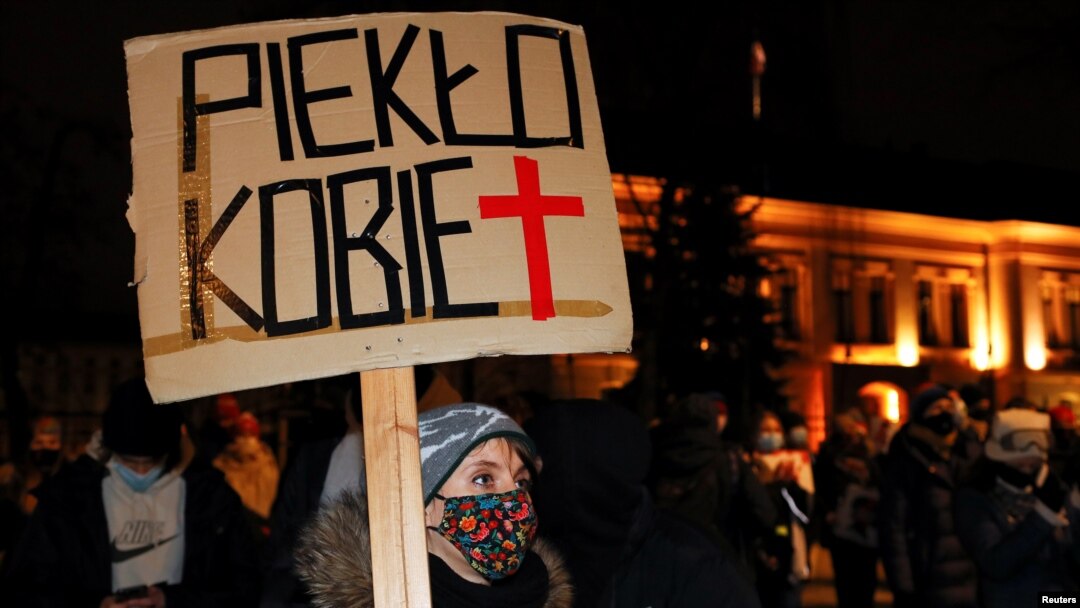 A demonstrator holds a placard reading "Women's hell" as she protests against a verdict restricting abortion rights in Warsaw, Poland, Jan. 27, 2021. 
