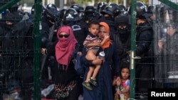 Migrants are sent back by Hungarian riot police at the border crossing with Serbia in Roszke, Hungary, September 16, 2015. Hungarian police fired tear gas and water cannon at protesting migrants demanding they be allowed to enter from Serbia on the second day of a border crackdown.