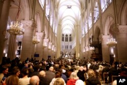 Faithful sit before the mass at Notre Dame Cathedral as the monuments hosts Christmas Eve services for the first time since a devastating 2019 fire, Dec. 24, 2024 in Paris.