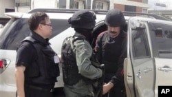 Alleged Russian arms trafficker Viktor Bout, right, escorted by Thai police commando, arrives at Don muang airport in Bangkok, 16 Nov 2010