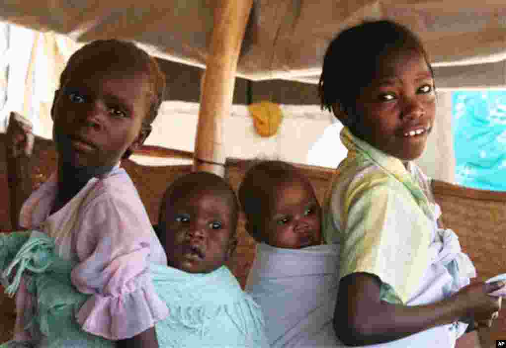 ** ADVANCE FOR MONDAY, MAY 28 ** Two refugee girls carry their mothers child at the south Darfur refugee camp of Kalma April 10, 2007. Now in its fourth year, the Darfur conflict has become the world's worst humanitarian crisis, and rape is its regular b