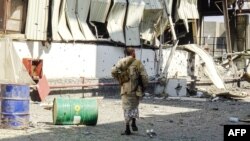 Members of the Yemeni pro-government forces walk through destruction in an industrial district in the eastern outskirts of the port city of Hodeida on Nov. 18, 2018, during the ongoing battle for control of the city from the Houthi rebels. 