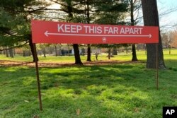 Signage urging social distancing is seen in Prospect Park in the Brooklyn borough of New York, April 8, 2020.