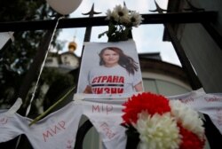 FILE - A view shows a photo of Belarusian opposition leader Sviatlana Tsikhanouskaya, which was attached to a fence by participants of a protest against presidential election results, outside the embassy of Belarus in Moscow, Russia, Aug. 14, 2020.