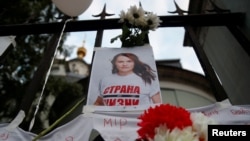 FILE - A photo of Belarusian opposition leader Sviatlana Tsikhanouskaya attached to a fence by participants of a protest against presidential election results, outside the embassy of Belarus in Moscow, Russia, Aug. 14, 2020.