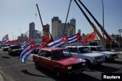 Autos Lada de la era soviética con banderas cubanas transitan el malecón, frente a la embajada de Estados Unidos en la isla, en protesta contra el embargo comercial contra Cuba, en La Habana, el 28 de marzo de 2021.