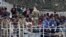 Migrants are seen aboard the British vessel HMS Enterprise before disembarking in the Sicilian harbor of Catania, Italy, Oct. 6, 2015. 