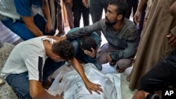 Palestinians mourn a relative killed in the Israeli bombardment of the Gaza Strip, at a hospital in Khan Younis, Aug. 24, 2024.