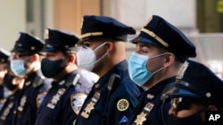 Polisi New York mengenakan masker di Gereja Katedral St. Patrick mengikut ibadah untuk menghormati 46 rekan polisi yang meninggal karena COVID-19, 5 Oktober 2020.