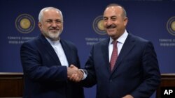 FILE - Foreign ministers Mohammad Javad Zarif of Iran, left, and Mevlut Cavusoglu meet in Ankara, Turkey, Aug. 12, 2016. Cavusoglu said he made a surprise visit to Tehran to enhance cooperation on Syria.