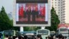 지난 2019년 6월 북한 평양역 광장에 설치된 대형 화면에서 북한 김정은 국무위원장이 중국에서 시진핑 주석 부부와 만난 소식이 나오고 있다.