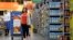 FILE - In this Nov. 9, 2017, photo, Laila Ummelaila, a personal shopper at the Walmart store in Old Bridge, N.J., pulls a cart with bins as she shops for online shoppers. 