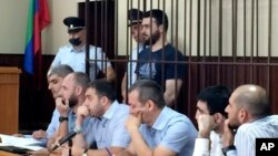 In this photo taken on Sunday, June 16, 2019, Abdulmumin Gadzhiev, the religious affairs editor of the independent weekly Chernovik, stands in a cage in a court room in Makhachkala, the Caspian Sea province of Dagestan, Russia, Sunday, June 16, 2019…