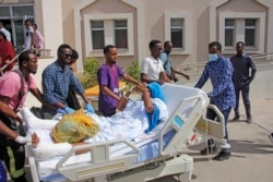 People escort a person on a hospital bed to be airlifted to Turkey for treatment after Saturday's truck bomb blast in Mogadishu, Somalia, Dec. 29, 2019.