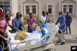 People escort a person on a hospital bed to be airlifted to Turkey for treatment after Saturday's truck bomb blast in Mogadishu, Somalia, Dec. 29, 2019.