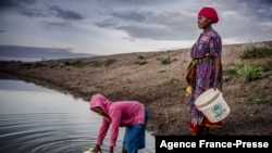 Martha Kasafi (kanan) dan putrinya,mengumpulkan air di Kabupaten Turkana, Kenya pada 2 Oktober 2019. (Foto: AFP)