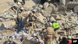 救援人员在叙利亚伊德利卜市据信被俄罗斯空袭摧毁的建筑废墟里寻找幸存者 (2015年12月21日)