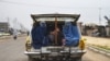 FILE - Afghan women and a boy travel in a taxi car on the outskirts of Mazar-i-Sharif, May 13, 2020.