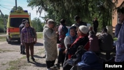 Người dân từ Vovchansk và các làng lân cận chờ xe buýt trong lúc sơ tán đến Kharkiv do pháo kích của Nga, tại một địa điểm không được tiết lộ gần thị trấn Vovchansk ở vùng Kharkiv, Ukraine, ngày 10 tháng 5 năm 2024.

