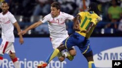 Moise Brou Apanga et le tunisien Youssef Msakni au stade de Franceville au Gabon le 31 janvier 2012.